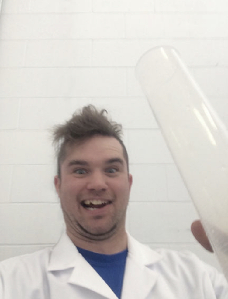 Our friend Bill holding up a large test tube with a crazy face.