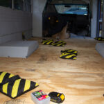 Spaced out sandbags holding down the glued plywood.