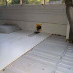 The seam between the van floor and the bus chassis.