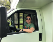 Steph in the driver's seat of the painted bus.